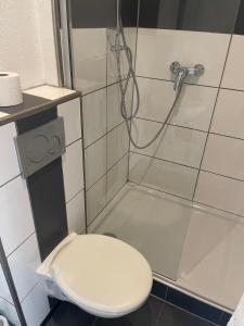 a bathroom with a toilet and a shower at Apartmenthaus am Rennplatz in Bremen
