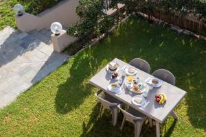 a table with plates of food on it in a yard at Elio A 1BDR Apt with Garden 1 min from the beach by Hospi in Heraklio Town