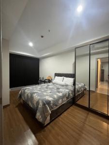a bedroom with a bed and a glass wall at DeAr Caspian Apartment in Surabaya