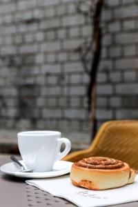 eine Tasse Kaffee und ein Stück Brot auf dem Tisch in der Unterkunft VISIONAPARTMENTS Basel Nauenstrasse - contactless check-in in Basel