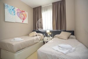 ein Schlafzimmer mit zwei Betten und einem Fenster in der Unterkunft Casa Andrea Ivan Luxury Homes 4ªPlta Sur 1ªLínea in Oropesa del Mar + 20 Fotos
