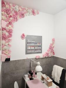 um salão com flores cor-de-rosa na parede em Andale SuiteSpa em Villa Badessa