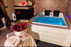 a bathroom with a tub filled with blue water at Andale SuiteSpa in Villa Badessa