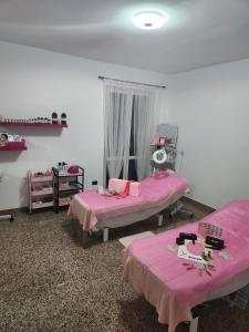 - 2 lits dans une chambre avec des draps roses dans l'établissement Andale SuiteSpa, à Villa Badessa