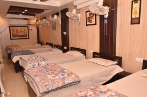 four beds in a row in a room at Hotel Comfort Hostel Charbagh Inn Lucknow in Lucknow
