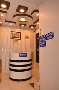 a lobby with a sign on the ceiling and a sign for a reception at Hotel Comfort Hostel Charbagh Inn Lucknow in Lucknow