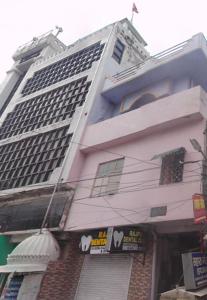 a tall white building with a store in front of it at Hotel Comfort Hostel Charbagh Inn Lucknow in Lucknow