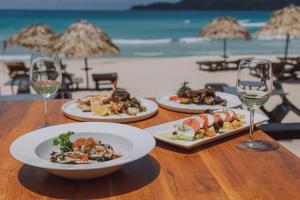 een tafel met borden en glazen wijn bij BuBu Villa in Perhentian Island