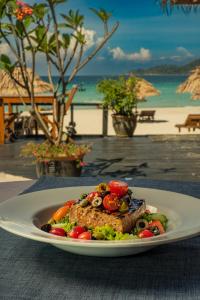 een bord met vlees en groenten op tafel bij BuBu Villa in Perhentian Island +37 foto's