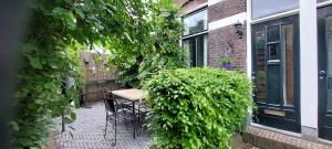 a patio with a table and some green bushes at Townhouse Center Arnhem in Arnhem