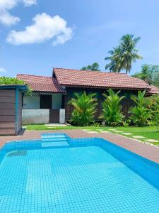 een zwembad voor een huis bij Kampung Tok Lembut Vacation Home in Pantai Cenang