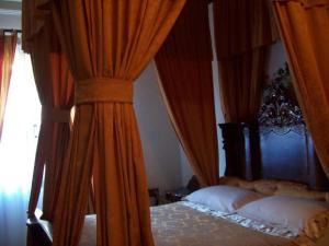 a bedroom with two beds with orange curtains at La Casa Nel Bosco in Beverino