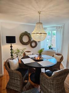 una sala da pranzo con tavolo, sedie e lampadario pendente di Appartements "Siebter Himmel" & "Wolke Sieben" Rosendomizil a Malchow