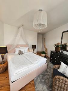 a bedroom with a white bed with a cat laying on it at Appartements "Siebter Himmel" & "Wolke Sieben" Rosendomizil in Malchow