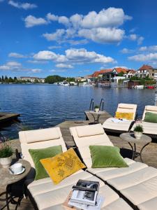 a view of a lake with chairs and a table at Appartements "Siebter Himmel" & "Wolke Sieben" Rosendomizil in Malchow