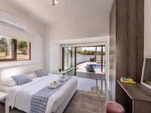a bedroom with a white bed and a view of a pool at Villa Socrates in Protaras