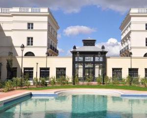 a swimming pool in front of a building with a gazebo at Disneyland Deluxe flat, outside pool, Climatisation, 1 min to Disney Parks in Serris