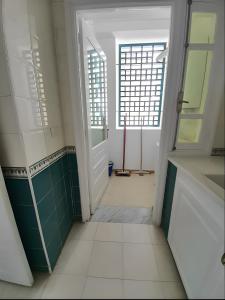 an empty bathroom with a door and a window at Ennasr 2 - Rez-de-Chaussée Chaleureux - Internet Fibre - Chaines International - Commerces et Services à Proximité - Service Navette in Ariana