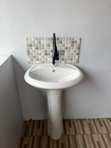 a white bathroom sink with a black faucet at Gemyah in Glagah +60 photos