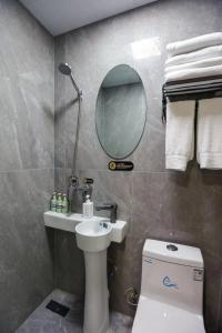 W łazience znajduje się umywalka, toaleta i lustro. w obiekcie KeTangJian Aparthotel w Szanghaju