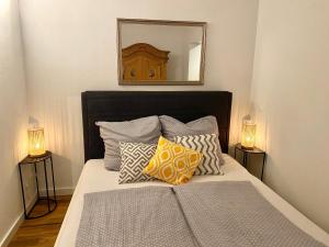 um quarto com uma cama com almofadas e um espelho em Ferienwohnung Seesprung am Bodensee em Gaienhofen