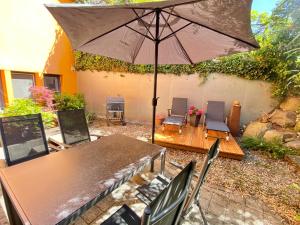a patio with an umbrella and a table and chairs at Ferienwohnung Seesprung am Bodensee in Gaienhofen