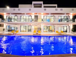 a swimming pool in front of a house at night at Qube Resort Kep in Kep