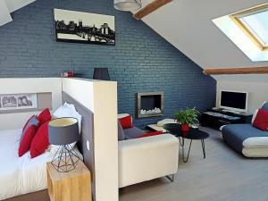 a loft bedroom with a bed and a couch at Les Suites Angevines in Angers