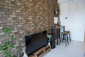 a brick wall with a fireplace in a living room at REVISION Kairouyama-tei - Vacation STAY 15801 in Hiroshima