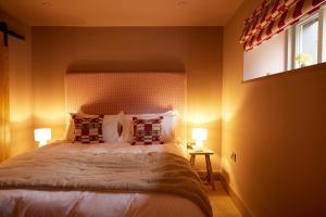 - une chambre avec un lit avec deux oreillers et une fenêtre dans l'établissement The Old Winery Cottage No2, à Shepton Mallet