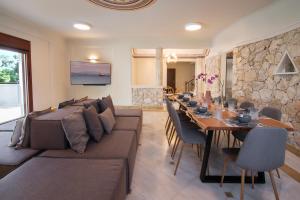 een woonkamer met een bank en een lange tafel bij villa lion in Agioi Theodoroi