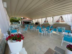 un restaurant avec des tables, des chaises et des chaises bleues dans l'établissement Angelina Hotel, à Ormos Panagias