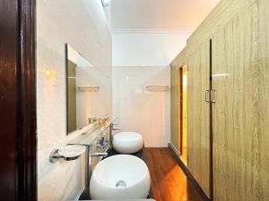 Tuna Homestay Hanoi & Experience في هانوي: حمام مع مرحاضين ومغسلة ومرآة
