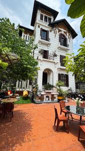 Tuna Homestay Hanoi & Experience في هانوي: منزل أمامه طاولات وكراسي