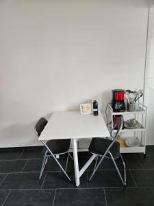 a white table and two chairs in a kitchen at Chambre d'Hôte Confort Ettelbruck in Ettelbruck
