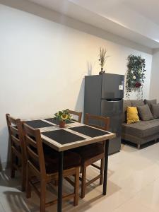a dining room with a table and a refrigerator at DeAr Caspian Grand Sunkono Lagoon Apartment in Surabaya