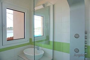 ein Badezimmer mit Waschbecken und Glasdusche in der Unterkunft Angelina Hotel in Ormos Panagias + 55 Fotos