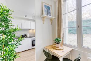 a kitchen and dining room with a table and chairs at Le Nid Cozy - Face Gare De Corbeil in Corbeil-Essonnes