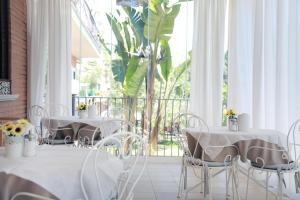 2 mesas y sillas en una habitación con ventana grande en BeB Villa Pacifica, en Peschici