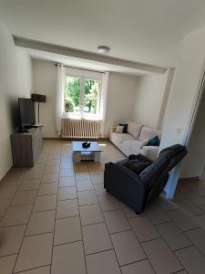 a living room with a couch and a tv at Appartement T2 cosy in Gourdon-en-quercy