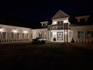 an old car parked in front of a house at night at Dworek MARINO KOŁOBRZEG in Grzybowo