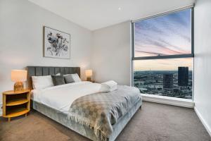 a bedroom with a bed and a large window at Sub-penthouse Stunning With Water Frontage 3B2B1C in Melbourne