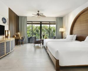 a hotel room with a large bed and a desk at Novotel Phu Quoc Resort in Phu Quoc