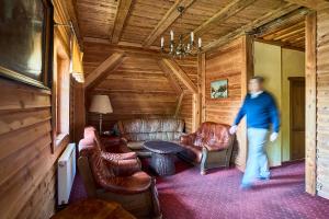 a man walking through a living room with leather furniture at Jaś i Małgosia in Szklarska Poręba