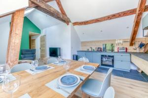 a dining room and kitchen with a wooden table and chairs at Meije - 3 Belles chambres - Calme - Wifi - Vue in Le Bourg-dʼOisans