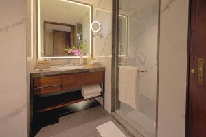 a bathroom with a sink and a mirror at Taj Bangalore in Devanahalli-Bangalore