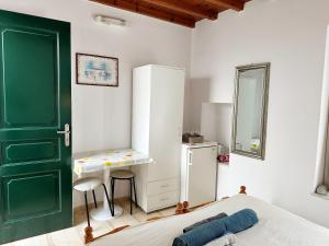 - une chambre avec une porte verte, un lit et un bureau dans l'établissement LaLaLand, à Mykonos