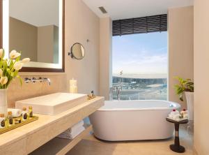 a bathroom with a tub and a large window at Taj Bangalore in Devanahalli-Bangalore