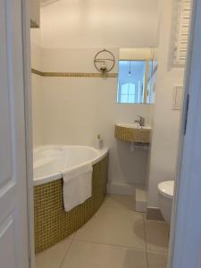 La salle de bains est pourvue d'une baignoire, d'un lavabo et de toilettes. dans l'établissement Dworcowa przy basenie, à Olsztyn