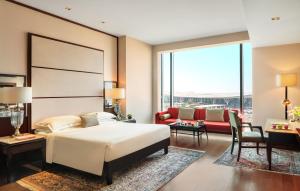 a hotel room with a bed and a couch at Taj Bangalore in Devanahalli-Bangalore